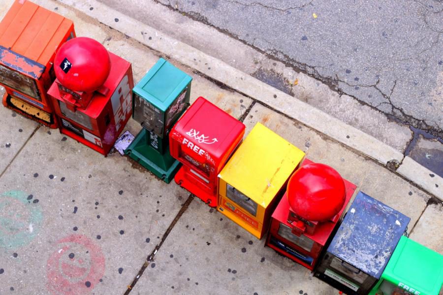 News paper boxes sit on a street corner