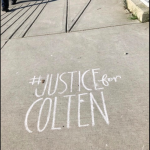 #JUSTICEforCOLTEN written in chalk on sidewalk.
