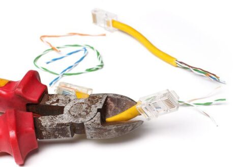 Bolt cutters cutting yellow cable with mulicoloured exposed strands.