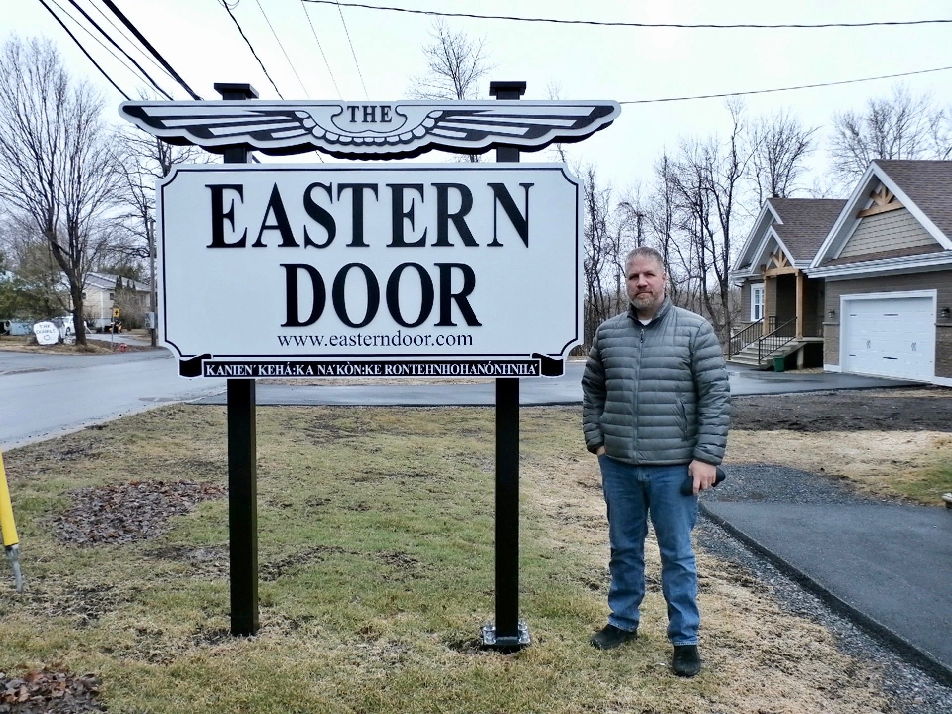 Steve Bonspiel stands in front of Eastern Door sign