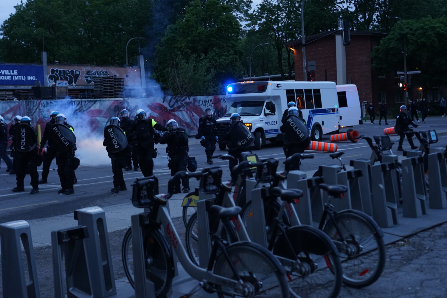 Police aiming a grenade launcher at journalists and a first aid table in front of Saint-Laurent Metro Station on May 31, 2020