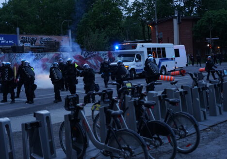 Police aiming a grenade launcher at journalists and a first aid table in front of Saint-Laurent Metro Station on May 31, 2020