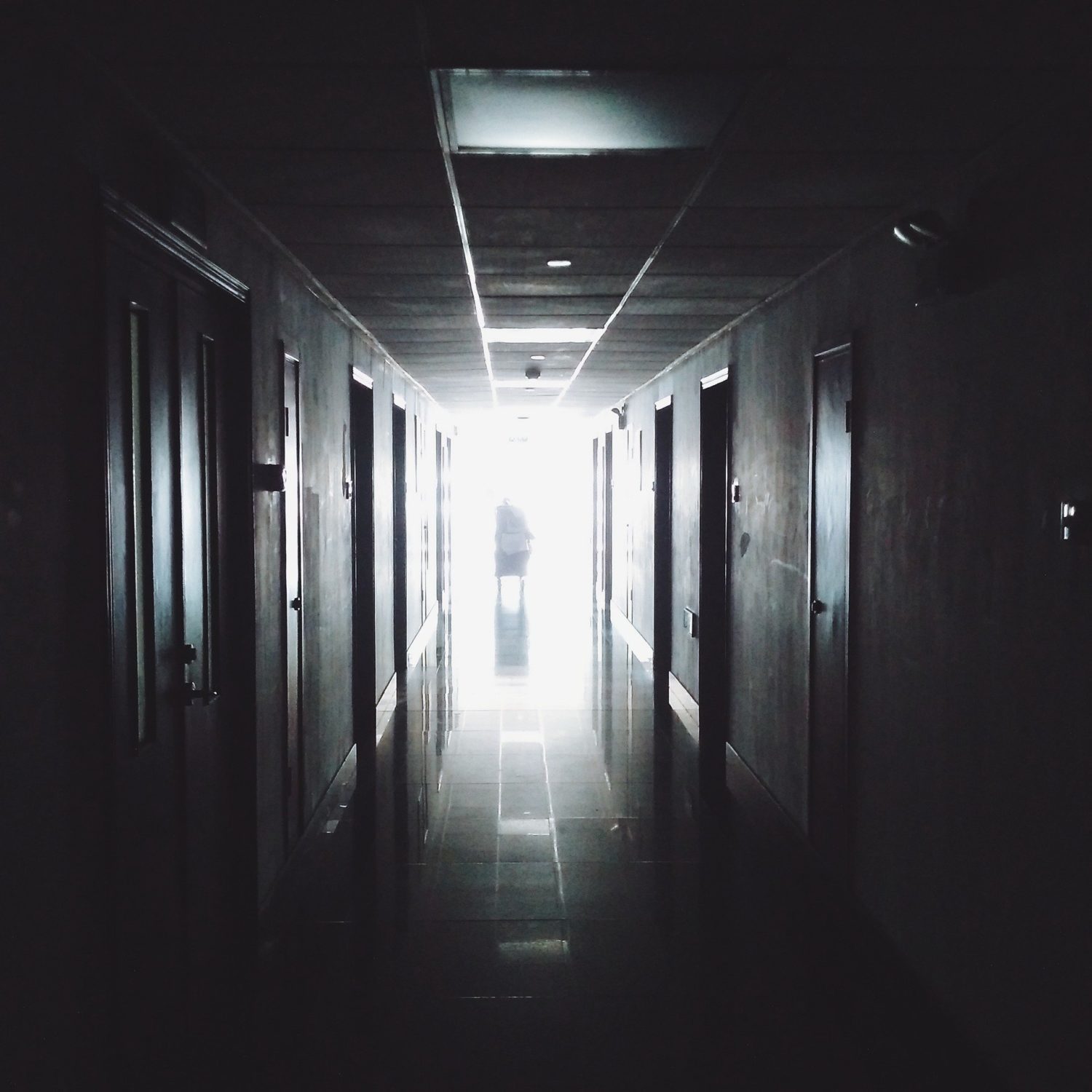 Dark hallway with silhoette or person standing at the end