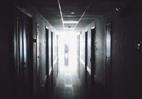 Dark hallway with silhoette or person standing at the end