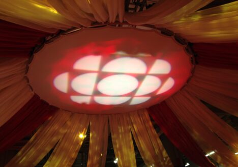 CBC red and white logo projected on ceiling surrounded by draperies.
