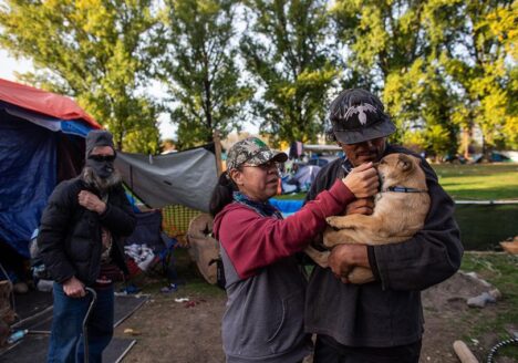 William Tomorowski and his partner Honey Turner play with their puppy Kalypso in the yard of their campsite at the Strathcona Park homeless encampment.