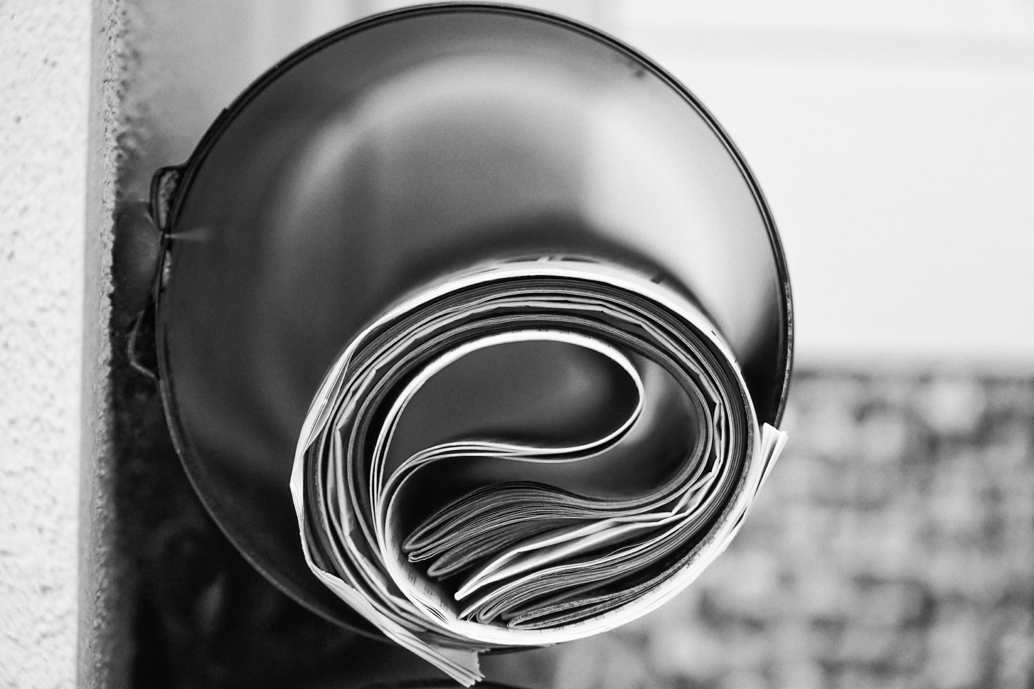Black and white image of newspaper rolled up inside of tube