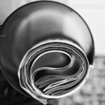 Black and white image of newspaper rolled up inside of tube