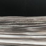 Stack of paper in front of black background.