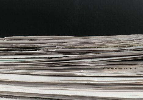 Stack of paper in front of black background.