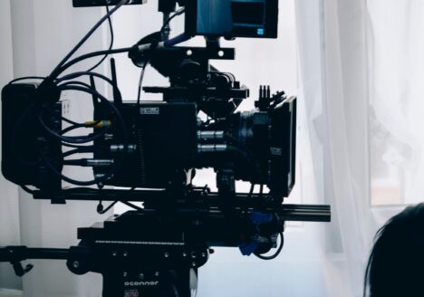 TV camera pointing right in front of a white curtain