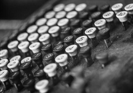 Close-up of vintage cash register in black and white.