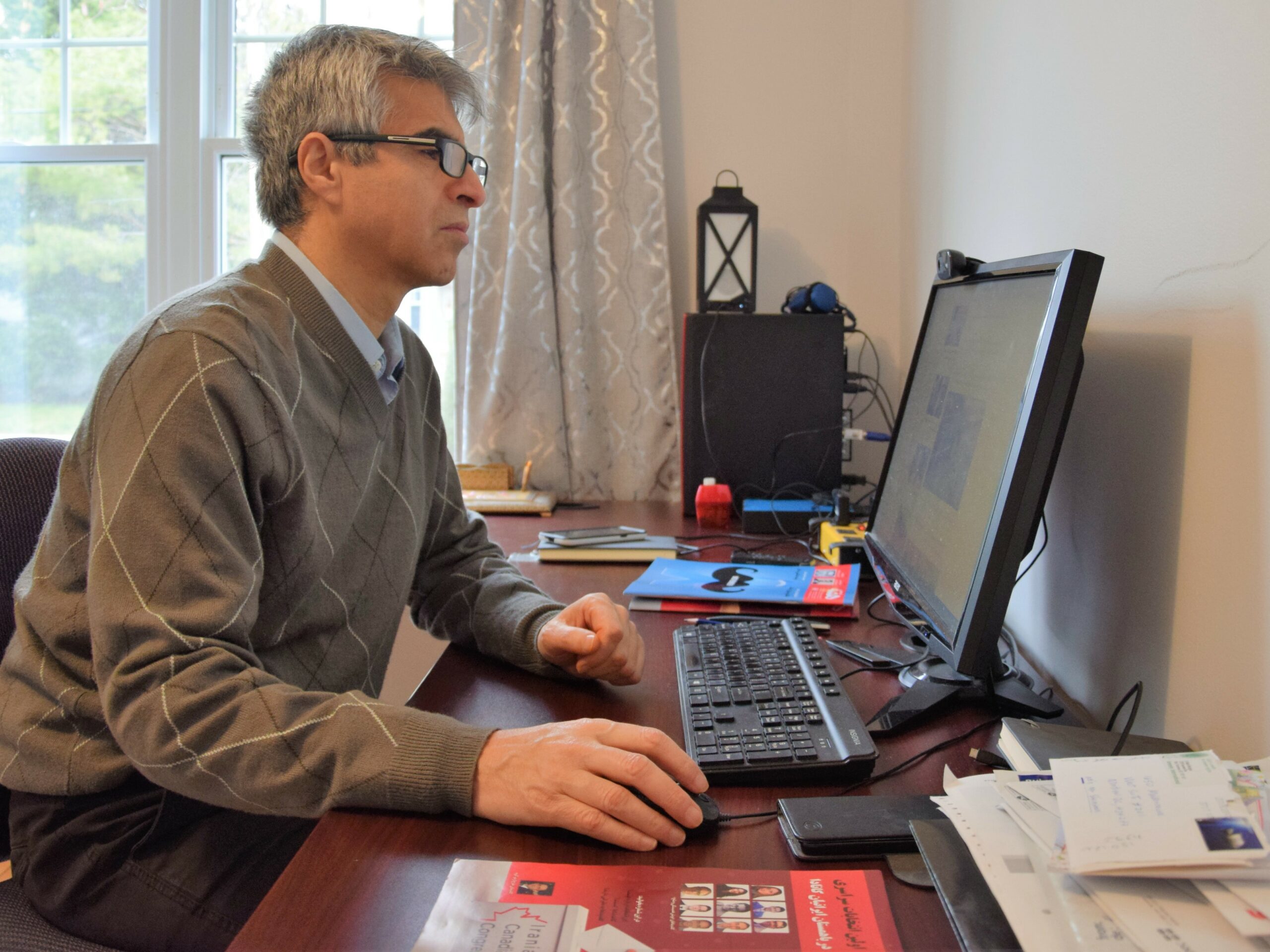 Khosro Shemiranie, HafteH’s publisher and editor-in-chief, works in his Montreal office.