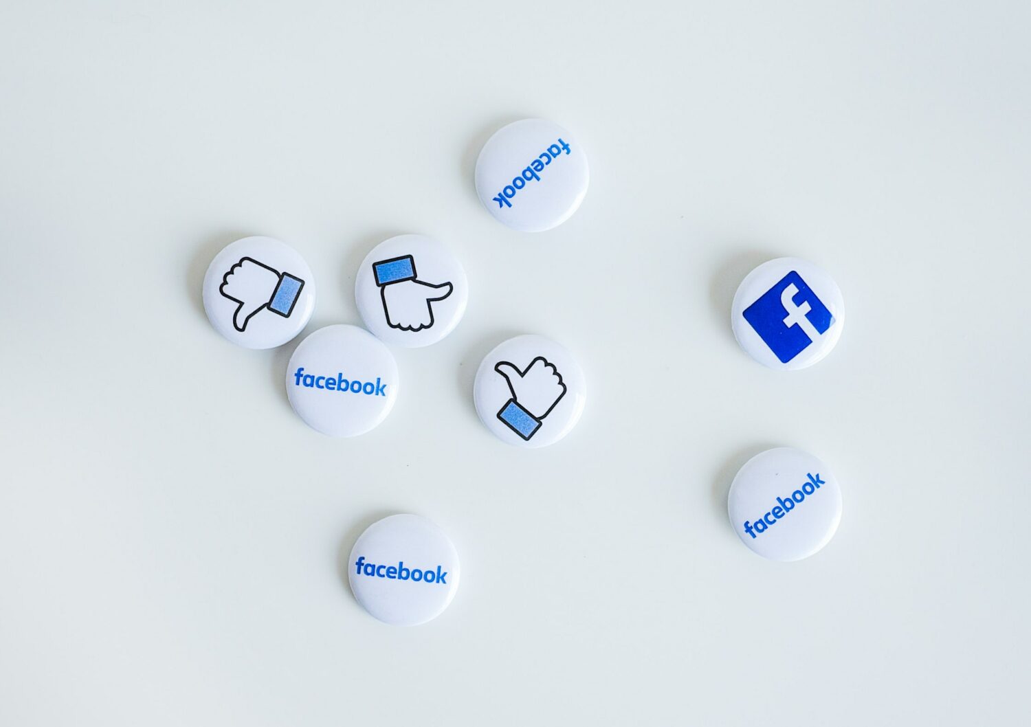 Buttons with blue Facebook name, logo and like icon on a white surface