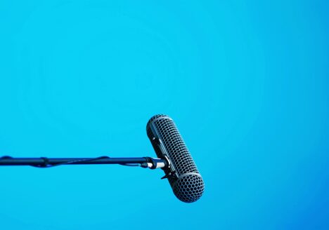 Horizontal microphone on stand over light blue background
