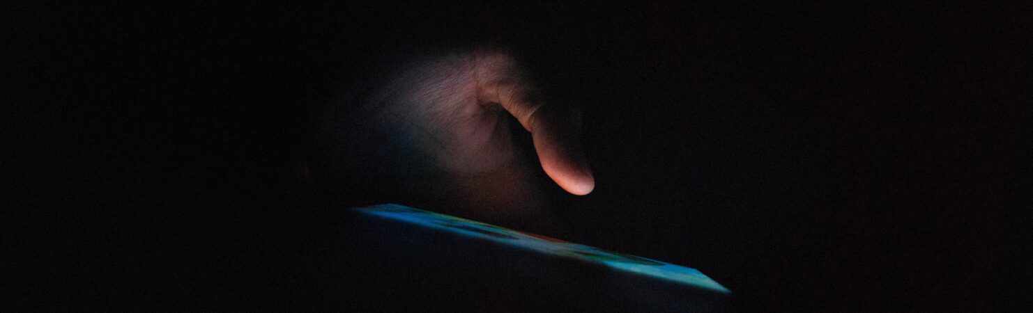 Hand holding smartphone in dark room