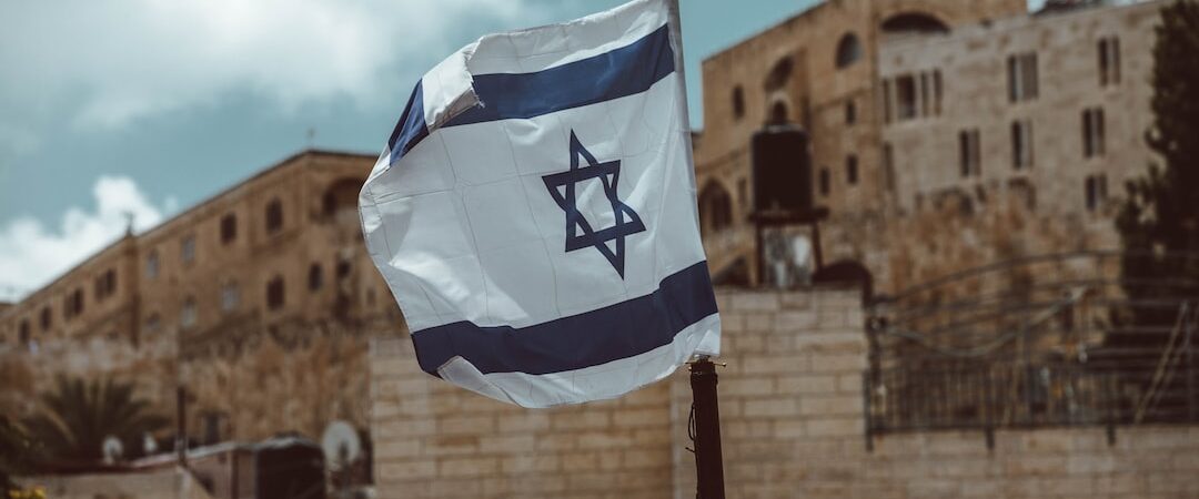 Photo qui montre un drapeau d'Israël devant des édifices.