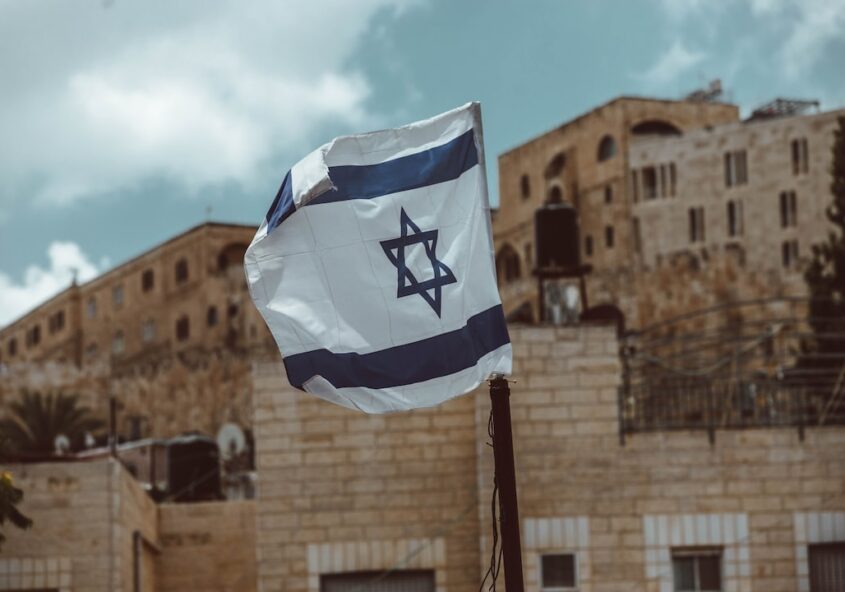 Photo qui montre un drapeau d'Israël devant des édifices.