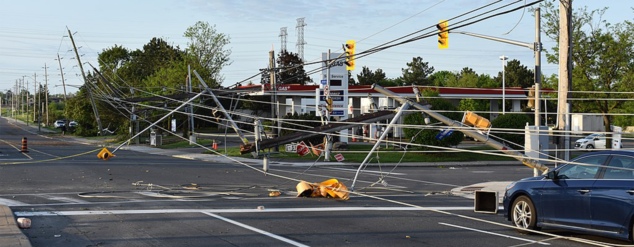 Powerlines lie across the road and trap a vehicle after a derecho passed through Ottawa in May 2022.