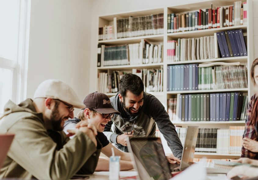 A group of students work in the library on a project