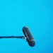 Horizontal microphone on stand over light blue background
