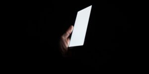 White phone screen held in dark room